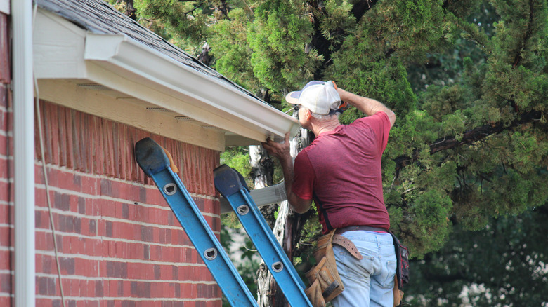 man repairing gutter