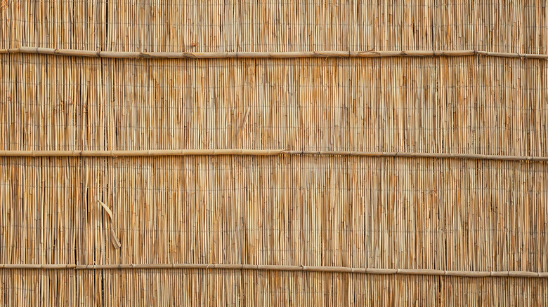 A fence made out of brown reeds