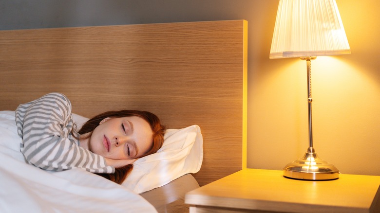 woman in bed with lamp on