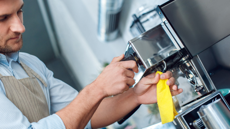 Person wiping coffee maker