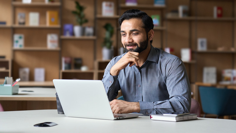 man smiling looking at laptop