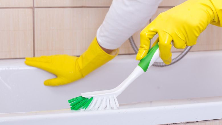 Person scrubbing a tub