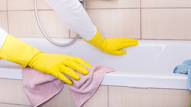 Person wiping a tub