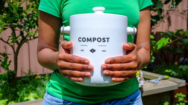 woman holding compost bin