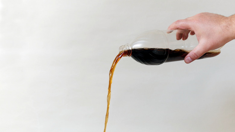 Hand pouring cola