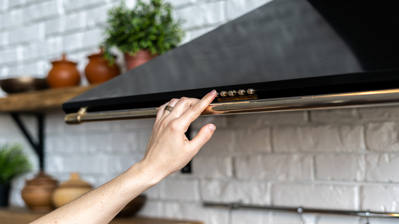 hand adjusting range hood setting