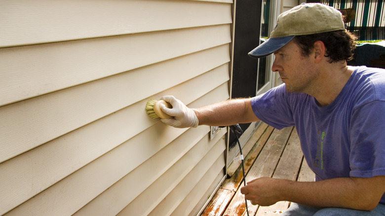 man washing siding