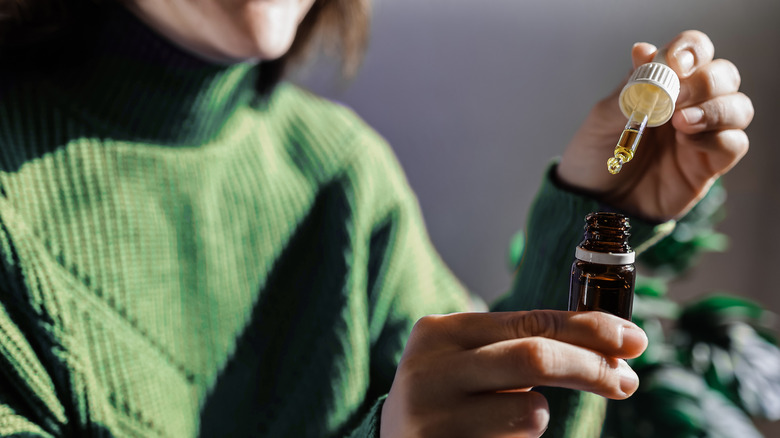 person holding essential oil bottle 