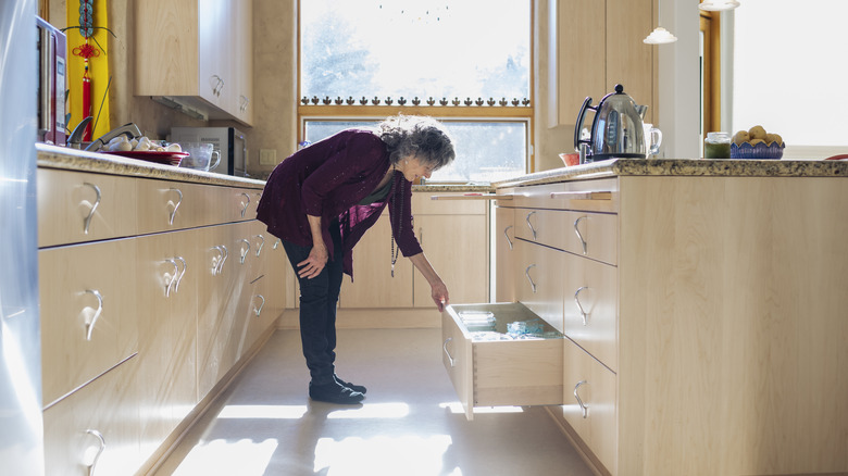 woman opening deep kitchen drawer