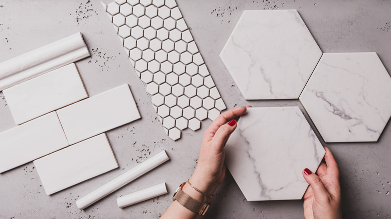 White subway, mosaic, and hexagon tiles laid out on a tabletop