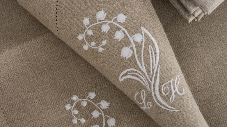 embroidered letters on tan napkin