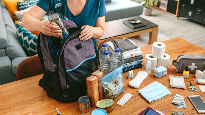 Woman filling emergency backpack