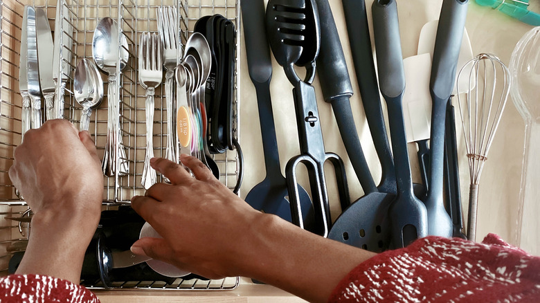 Hands sifting through silverware