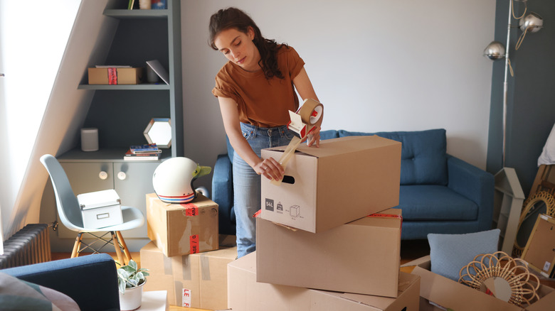 Woman taping up boxes in move