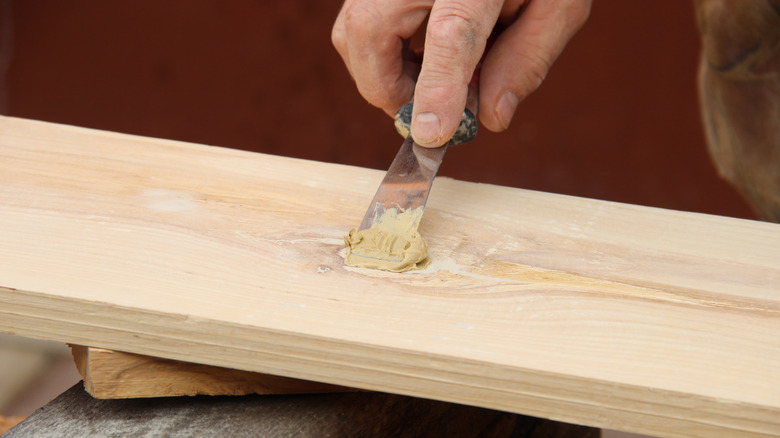 Hand applying wood putty