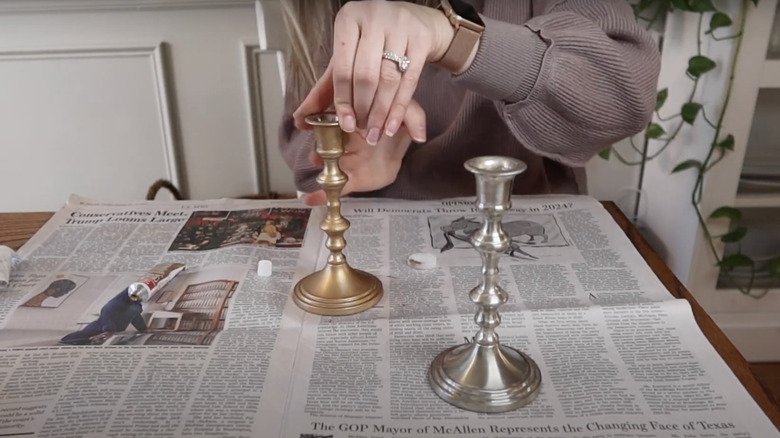 woman painting old candlesticks