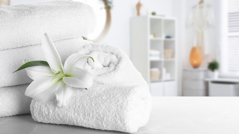 rolled white towels with flower