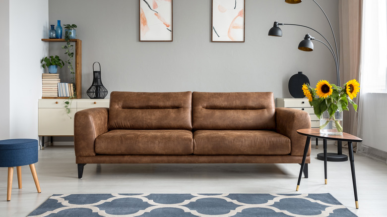 brown couch with blue accent rug