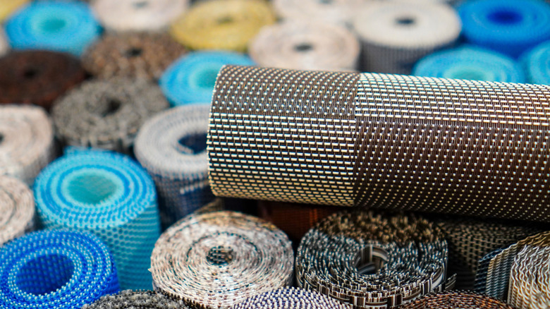 A roll of shelf liner sits on top of many other shelf liner rolls