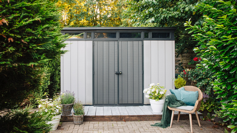 Gray shed and wicker chair