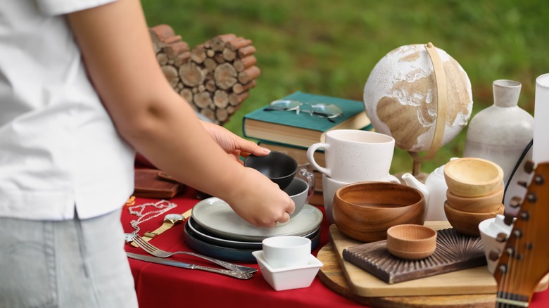 Woman lifting bowls at garage sale