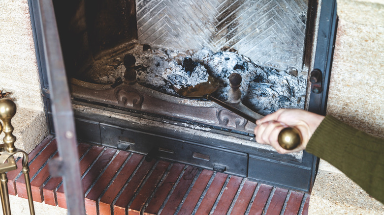 man cleaning fireplace