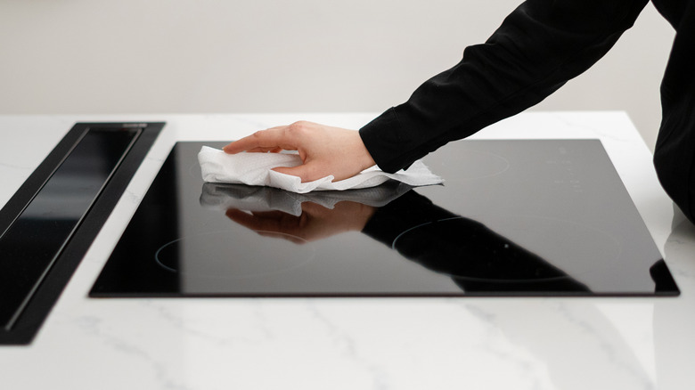 Woman's hand wiping glass top