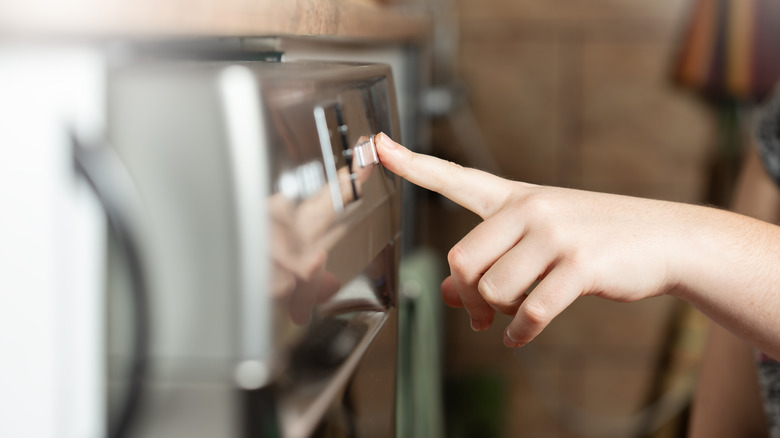 Pushing buttons on dishwasher