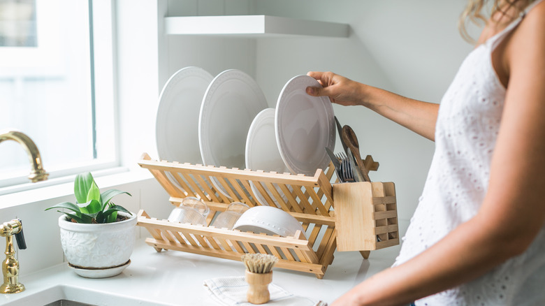 Woman placing dish on rack