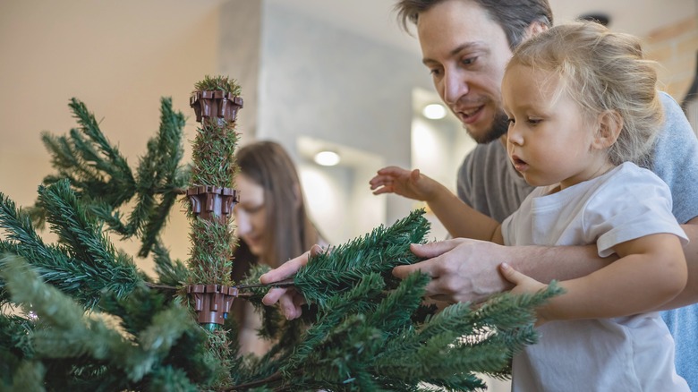 Family assembles Christmas tree