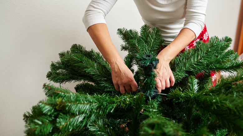 Woman assembles Christmas tree