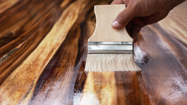 hand wiping wood floor