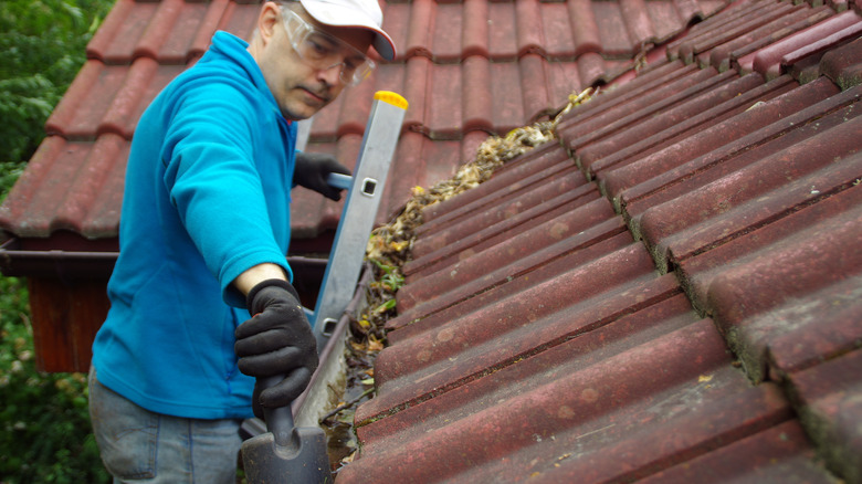 Man cleaning gutter