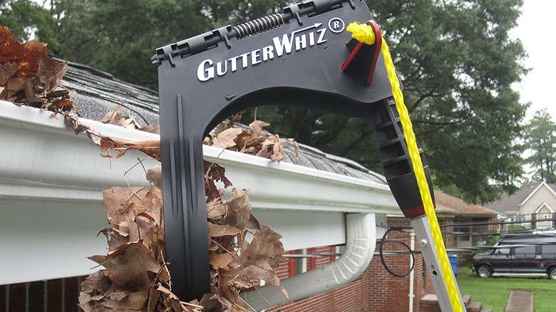 Gutter tongs picking debris off a gutter