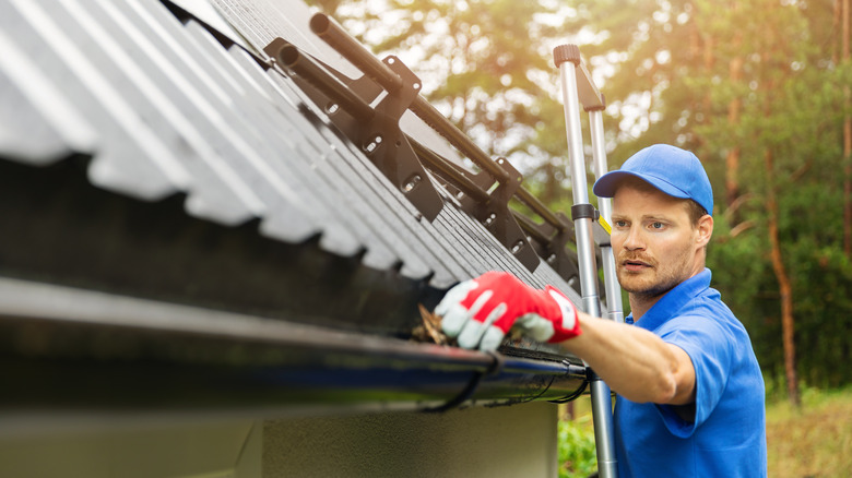 Professional gutter cleaner working