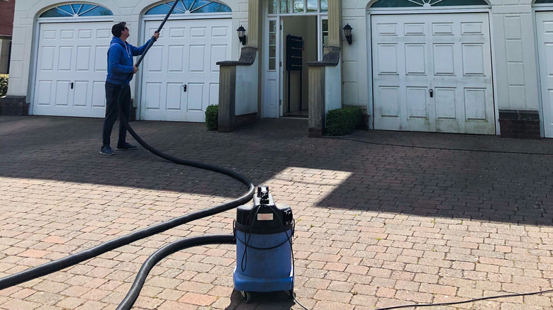 Man using gutter vacuum