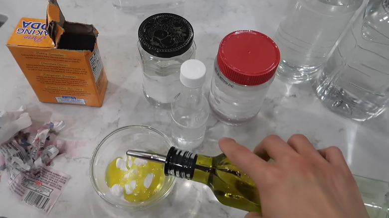 Hand pouring oil into jar