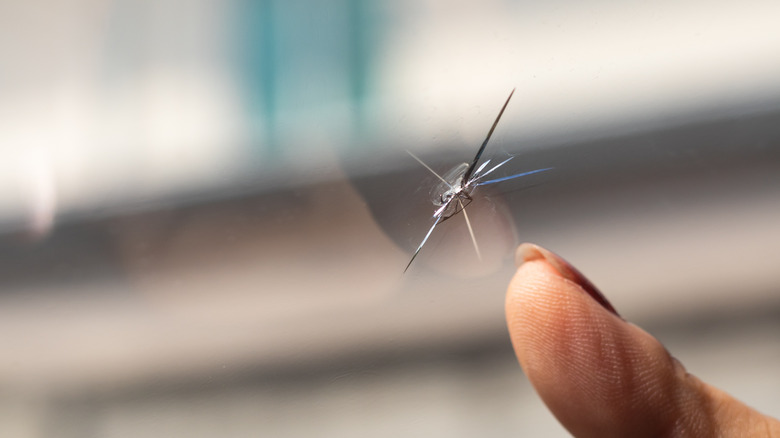 finger pointing at cracked window