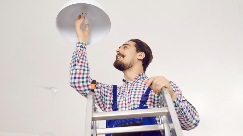 Person tightening lightbulb