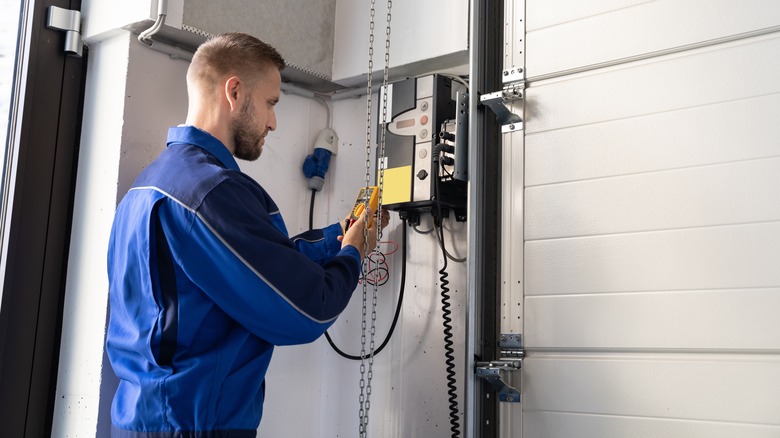 Repair man works on garage door