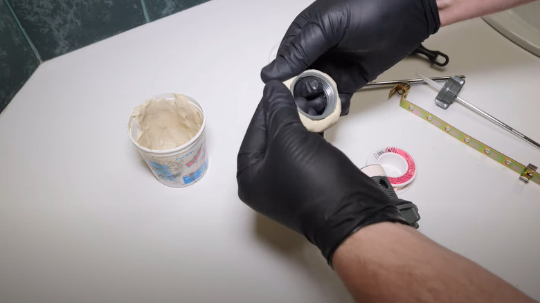 putting plumber's putty around flange