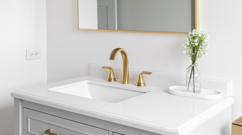 A new gold faucet on a bathroom sink