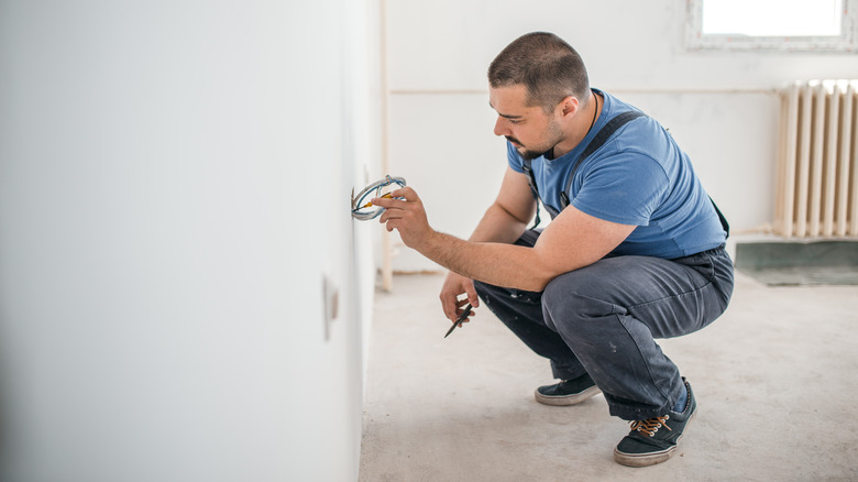 man working on electrical outlet