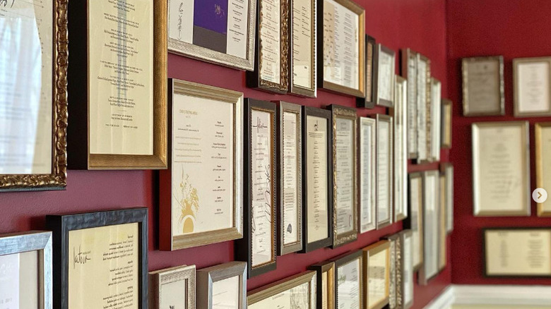 framed menus on red wall