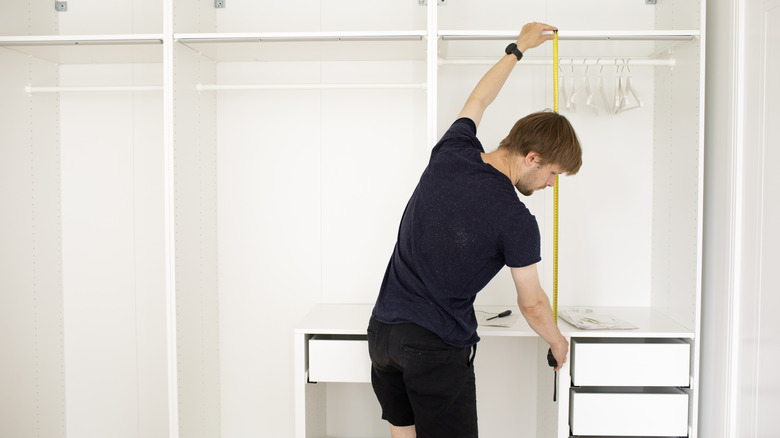 man measuring a wardrobe