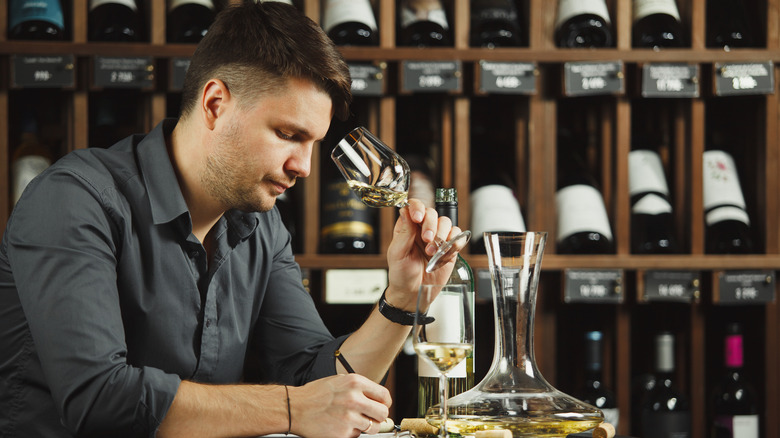 man writing in wine cellar