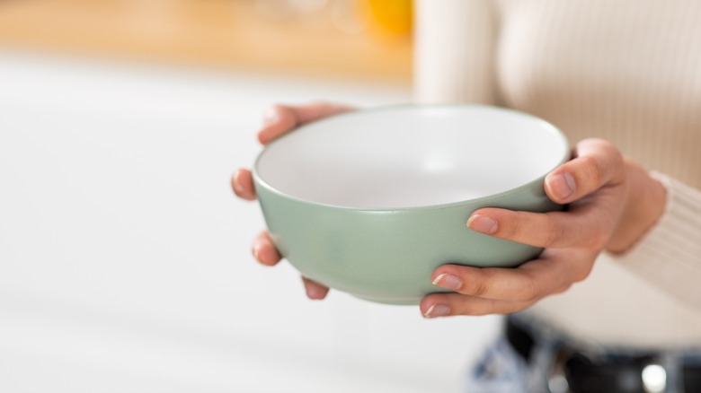 Someone holding a green bowl