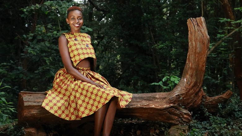 woman sitting on dead tree