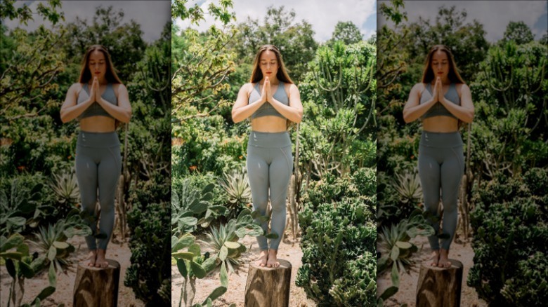 woman standing on tree stump