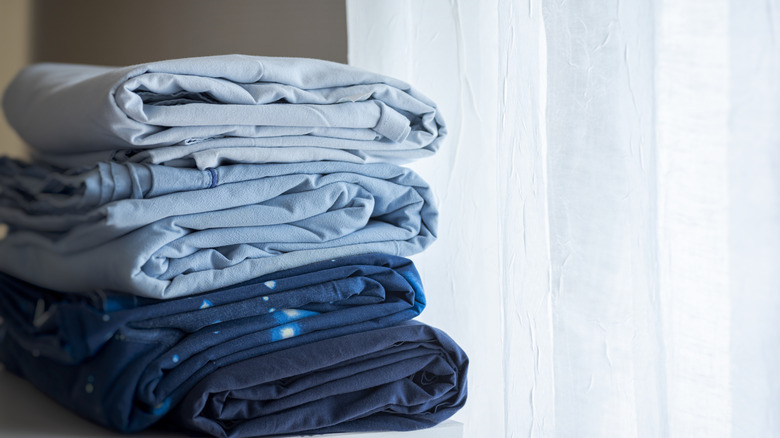 Blue folded sheets on table